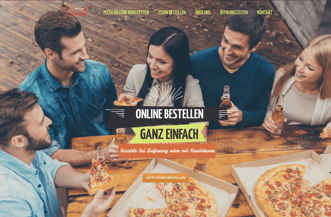 Eine Gruppe von Menschen sitzt um einen Pizza-Falcone-Tisch.