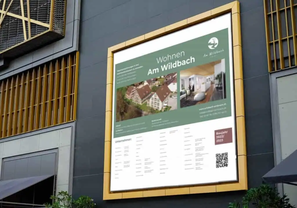 Eine Bautafel-Werbung, die die Immobilie „Am Wildbach“ an der Seite eines Gebäudes zeigt.